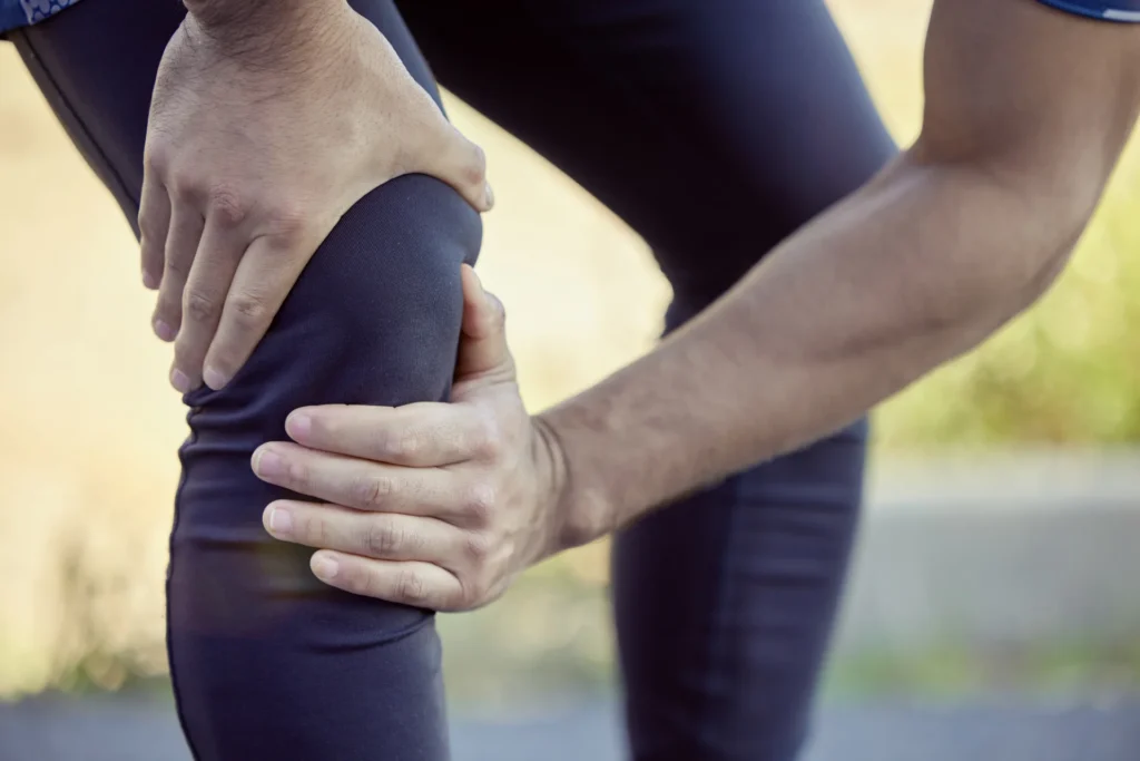 adult man holding his injured knee outside 2026 03 25 08 41 14 utc