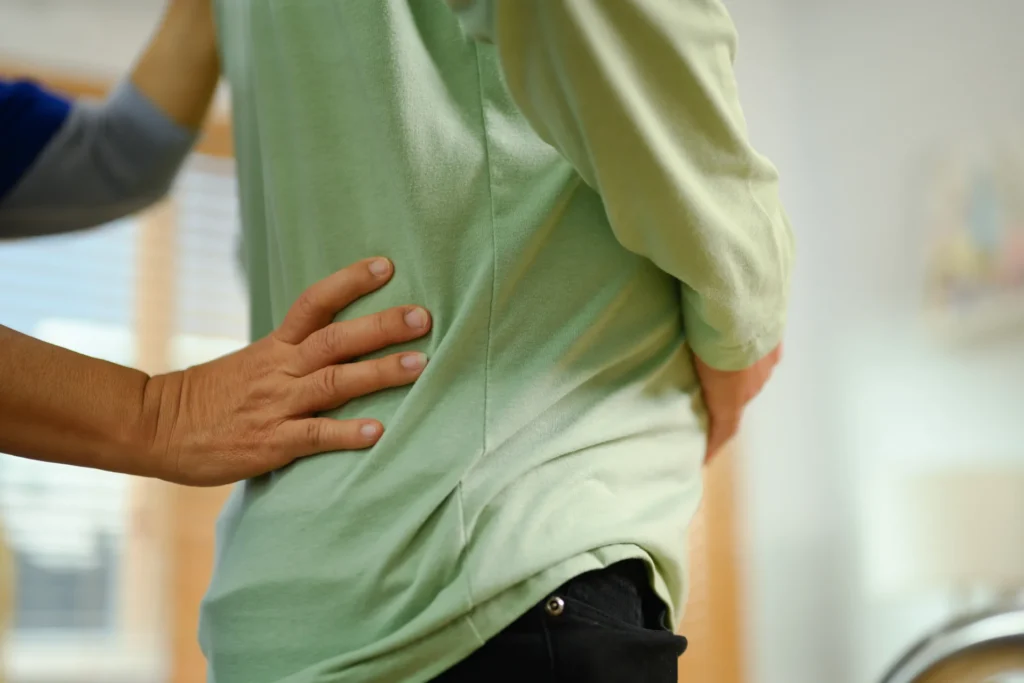 supportive hand on lower back in clinical setting 2026 01 06 09 31 33 utc